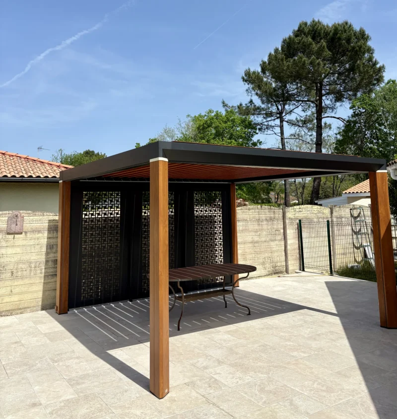 Vue extérieure de la pergola bioclimatique côté jardin, sous les pins