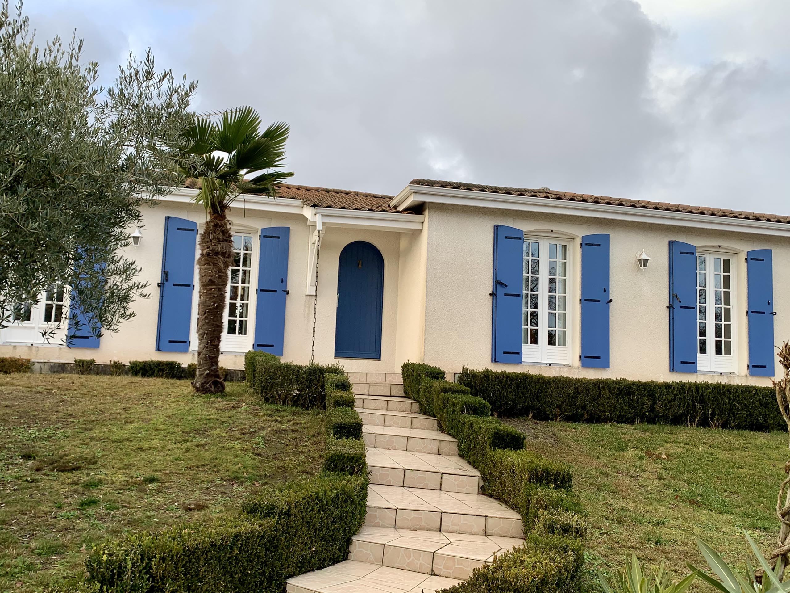 Volets battants bleus sur la façade d'une maison girondine