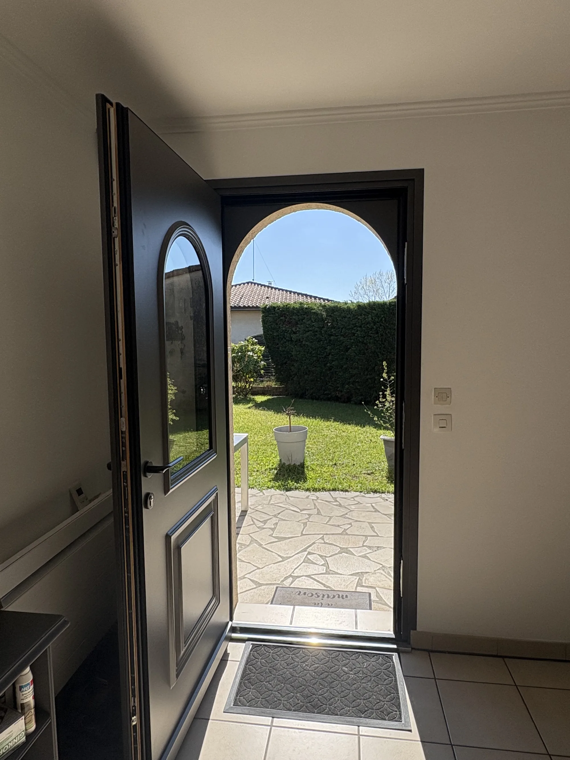 Détail du vitrage ovale de la porte de service donnant sur une terrasse en pierre naturelle