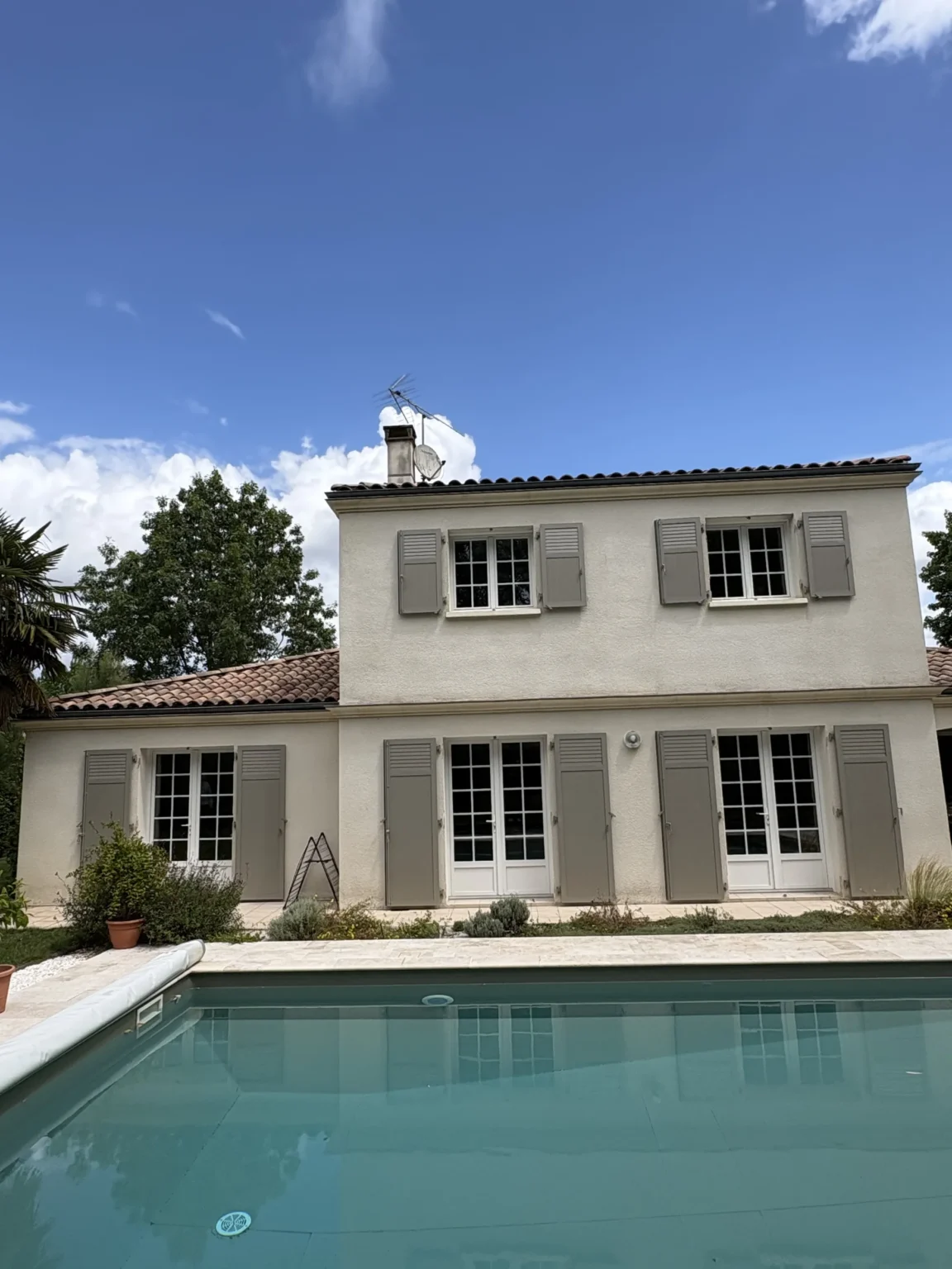 Vue d'ensemble de la façade et de la piscine après la pose des volets battants à Gradignan