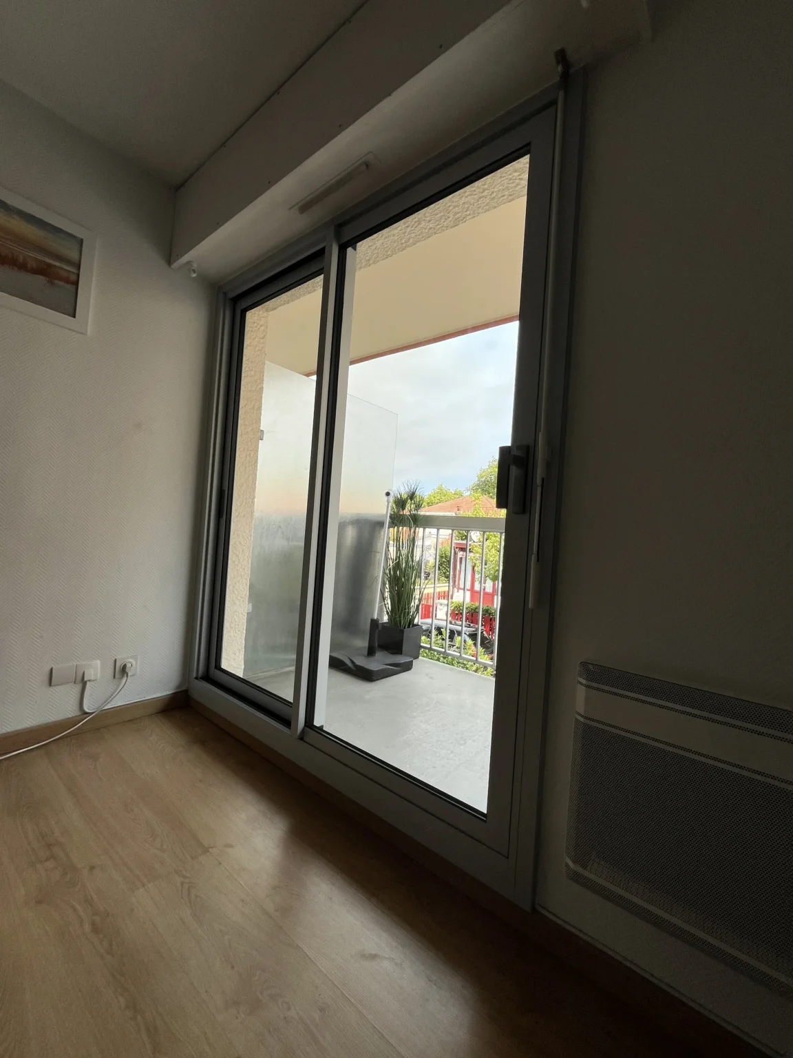 Vue intérieure du séjour, grand coulissant ouvert sur la loggia