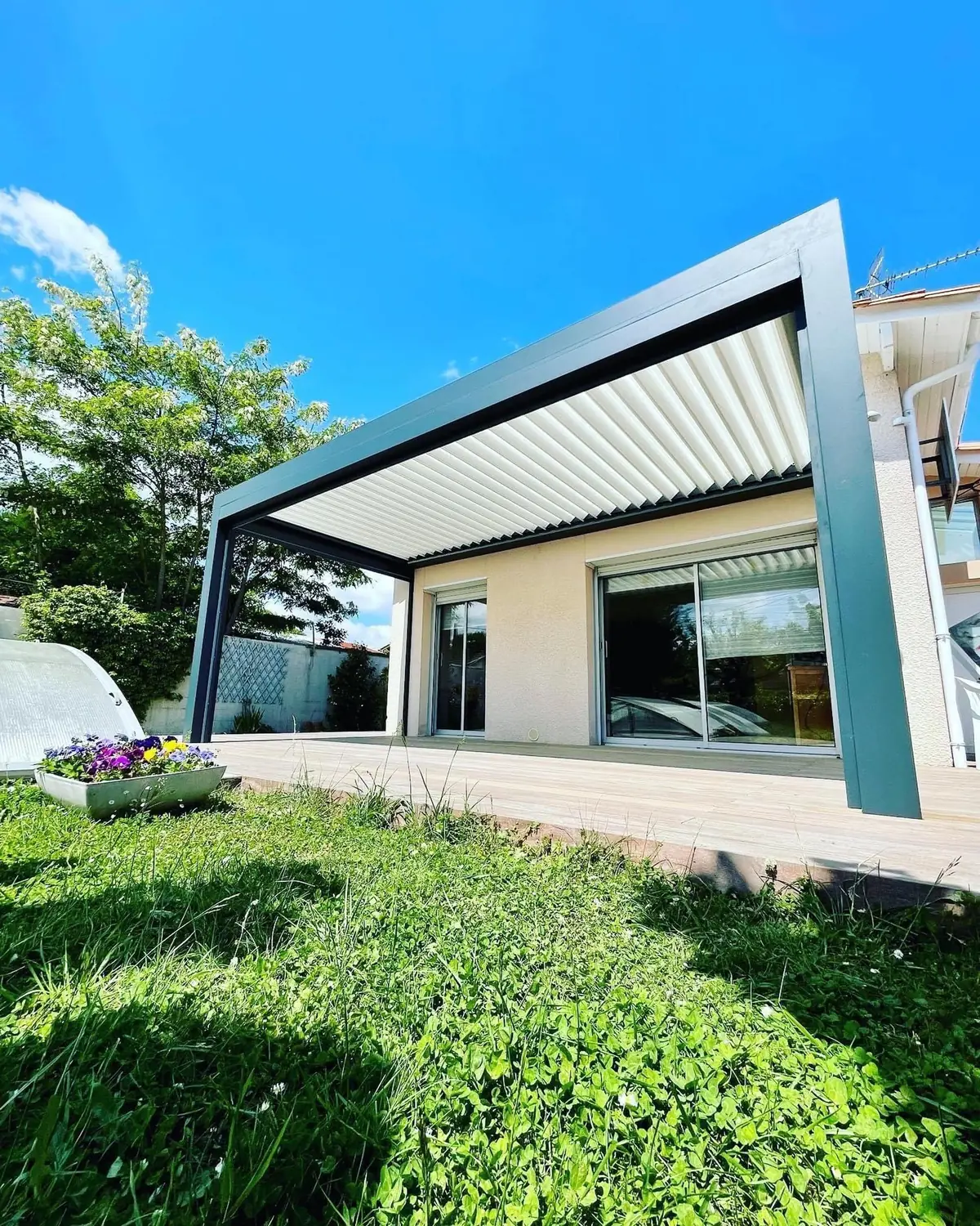 Pergola bioclimatique à lames orientables installée au-dessus d'une terrasse