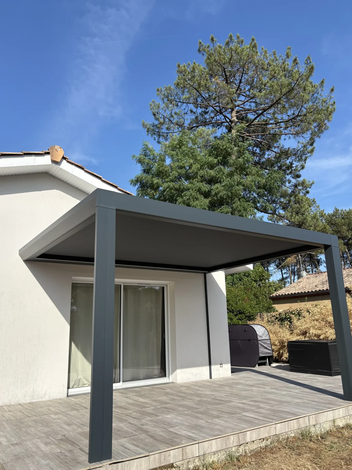 Structure aluminium anthracite de la Pergotoile vue d’angle depuis la terrasse