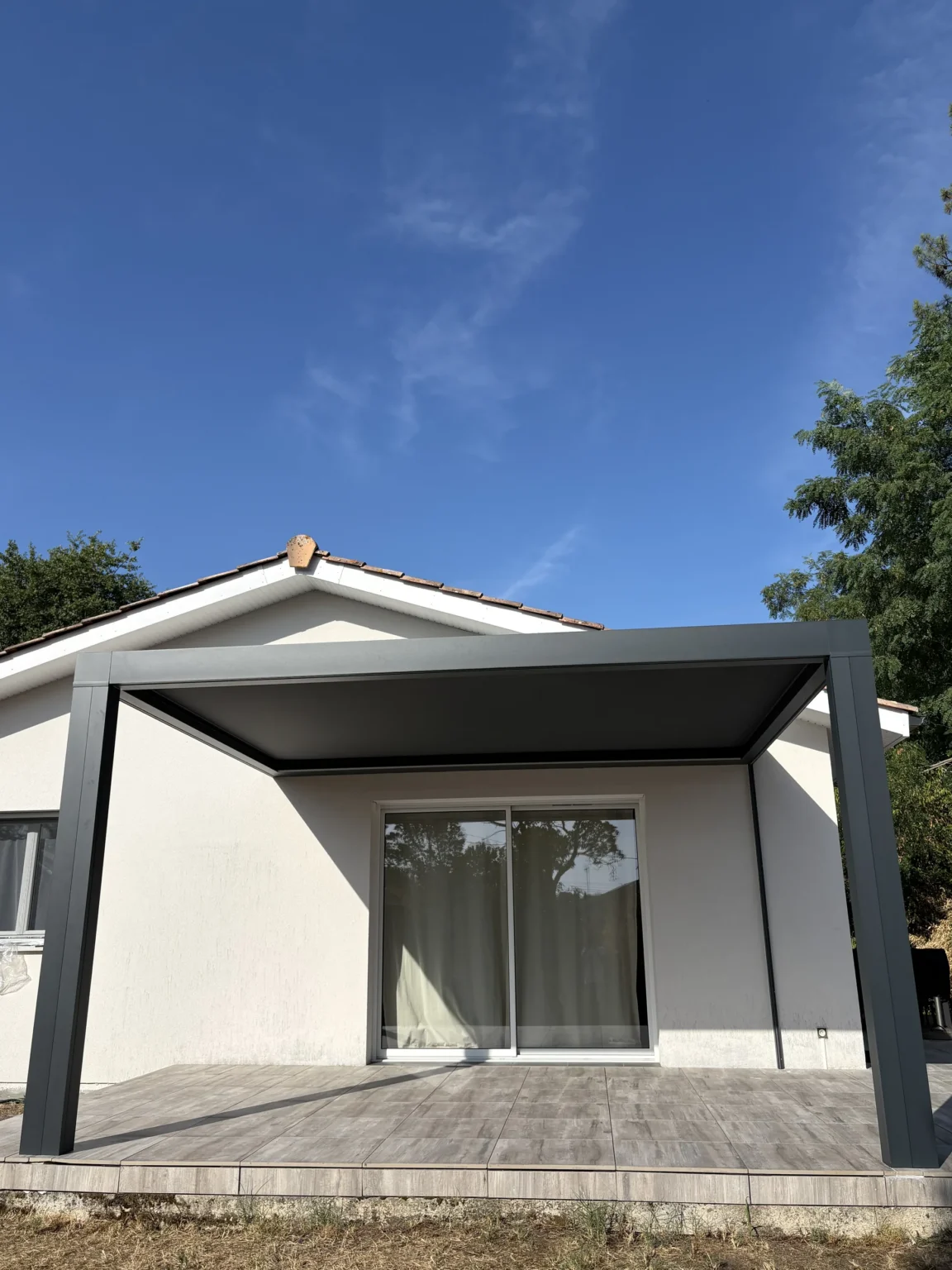 Pergola à toile tendue au-dessus d’une terrasse en lames composite
