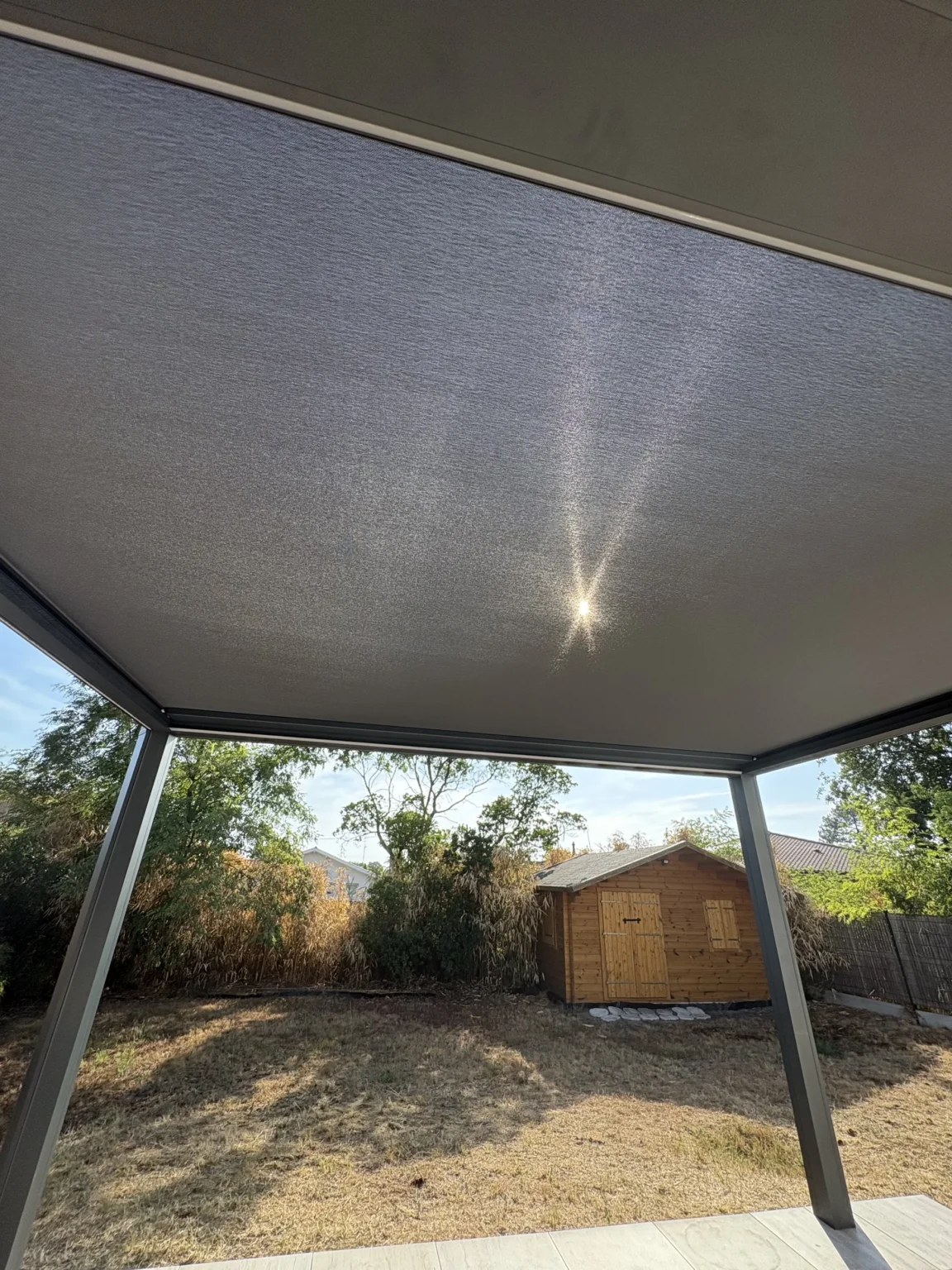 Toile micro-aérée vue de dessous, le soleil filtre à travers la trame