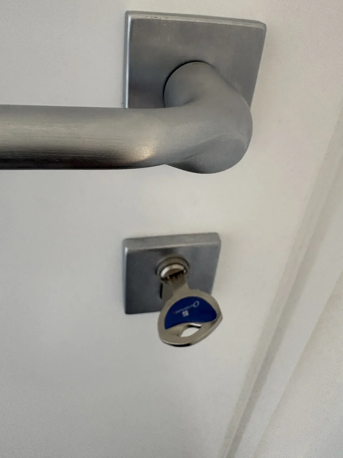 Détail de la poignée inox sur rosace carrée et du cylindre de sécurité