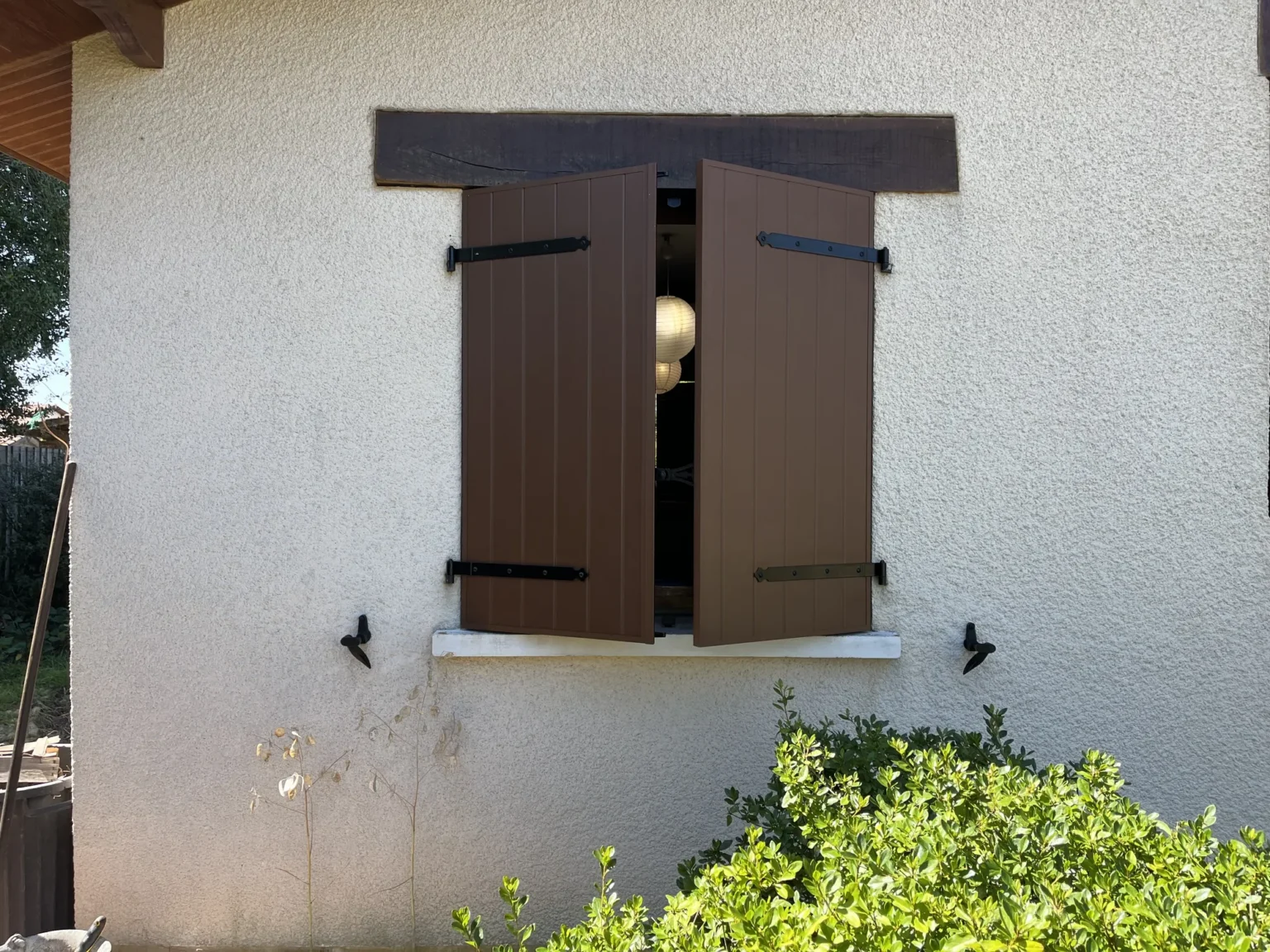 Volets battants aluminium mi-clos sous un linteau en bois teinté