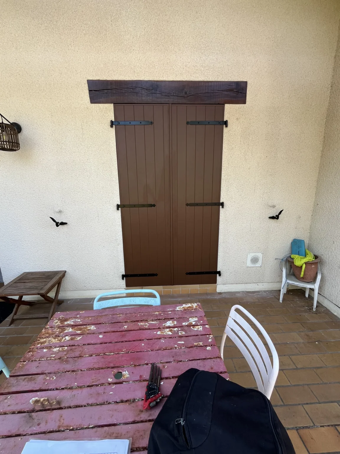Volets battants fermés sur la porte-fenêtre donnant sous l’auvent de la terrasse