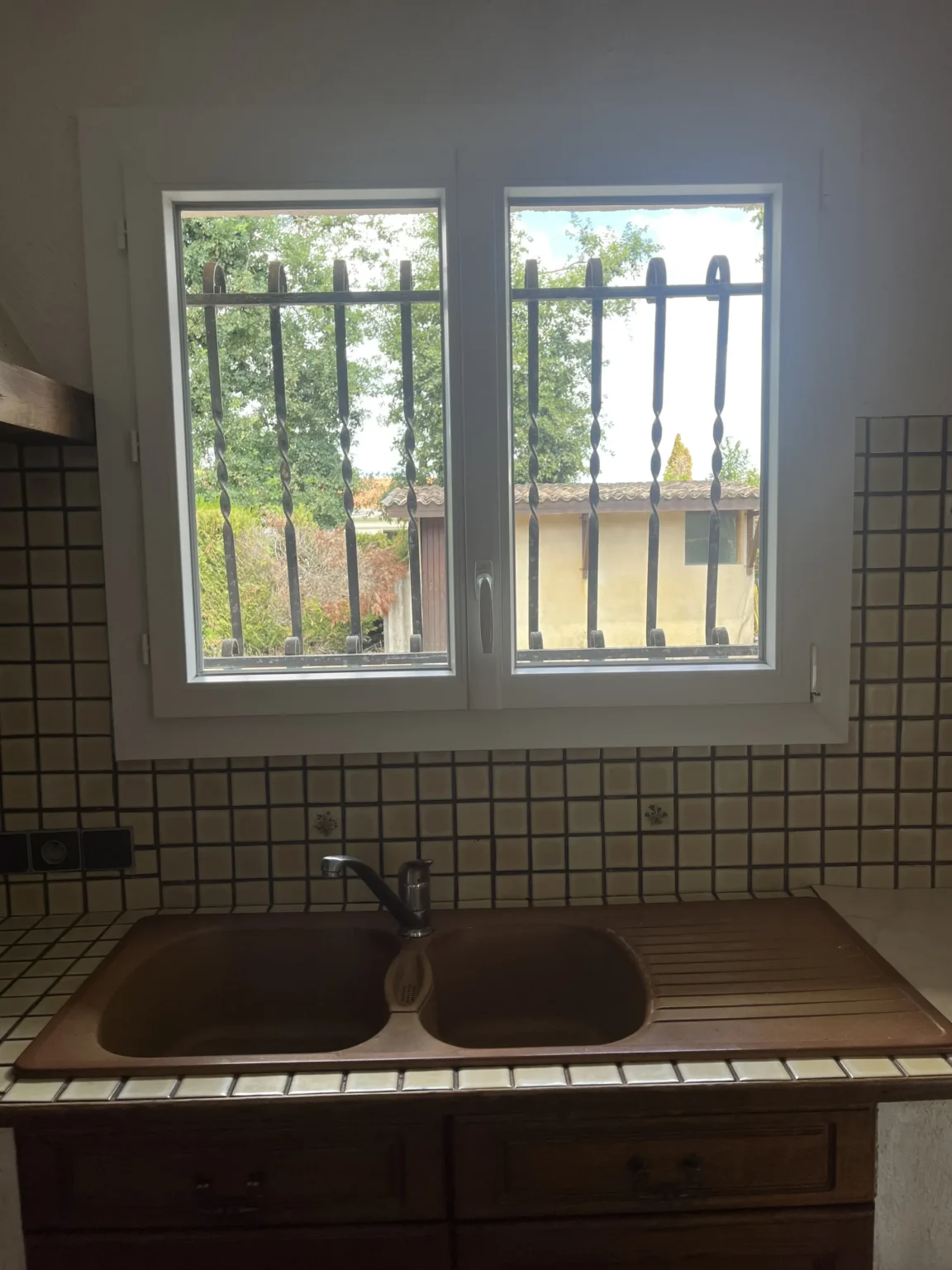 Fenêtre PVC de cuisine avec barreaudage en fer forgé conservé, vue intérieure, Saint-Jean-d’Illac