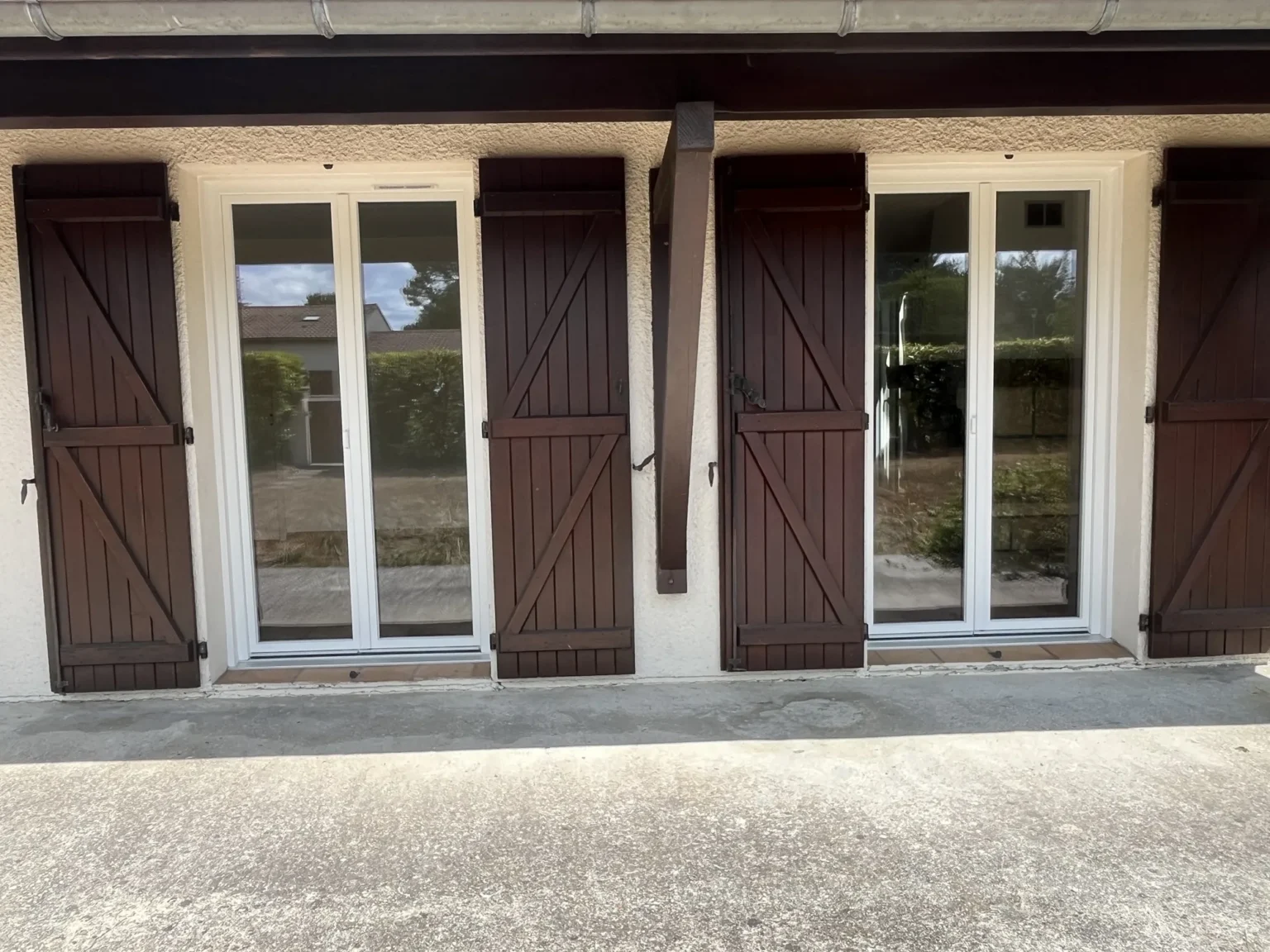 Deux fenêtres PVC blanches posées sur la dépendance d’une maison à Saint-Jean-d’Illac, sous la charpente apparente