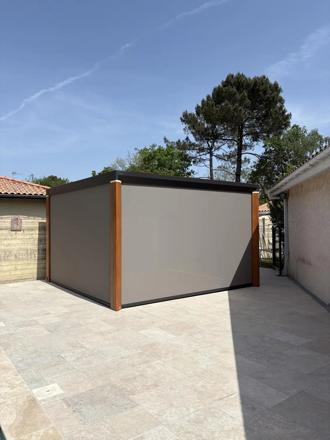 Pergola bioclimatique à stores screen déroulés sous un pin maritime