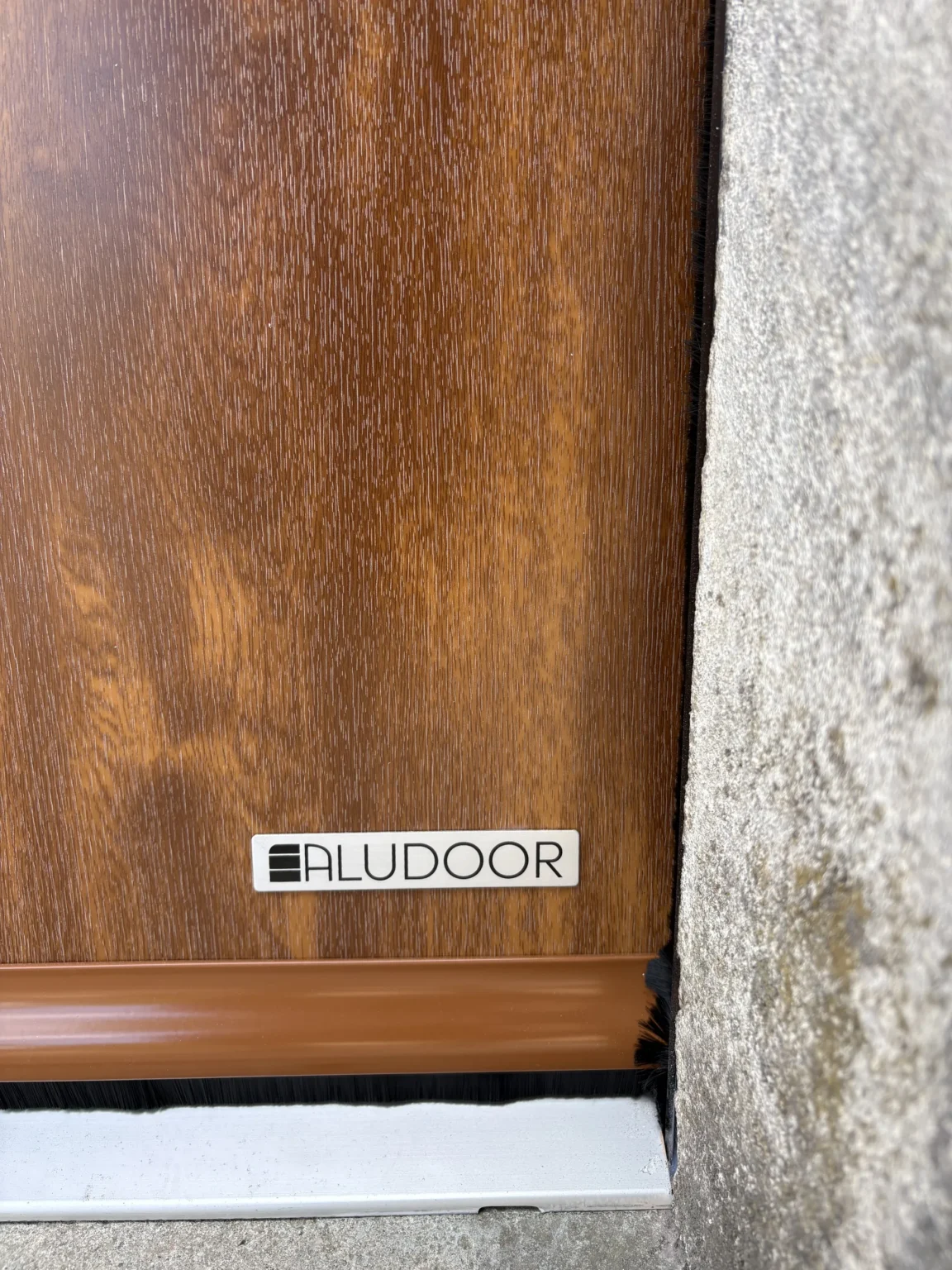 Plaque de marque Aludoor et joint brosse en pied de porte de garage sectionnelle, Martignas-sur-Jalles