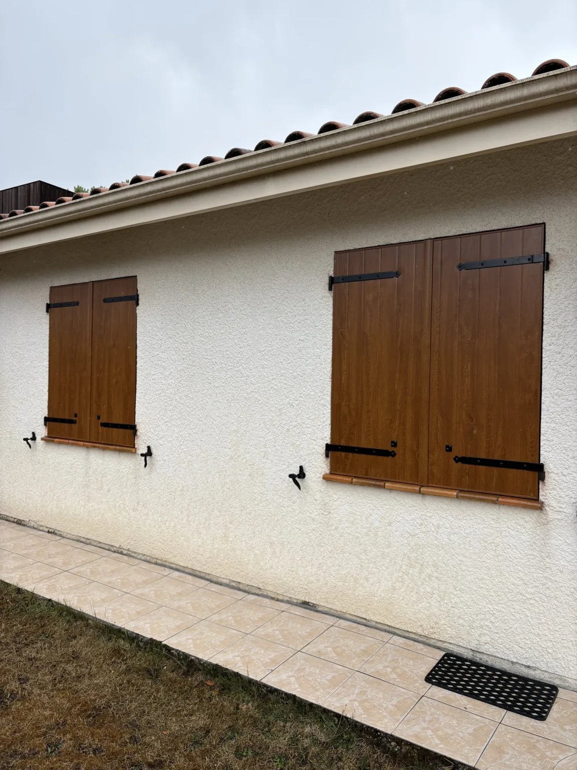 Volets battants aluminium chêne doré fermés sur une fenêtre de la façade, Martignas-sur-Jalles