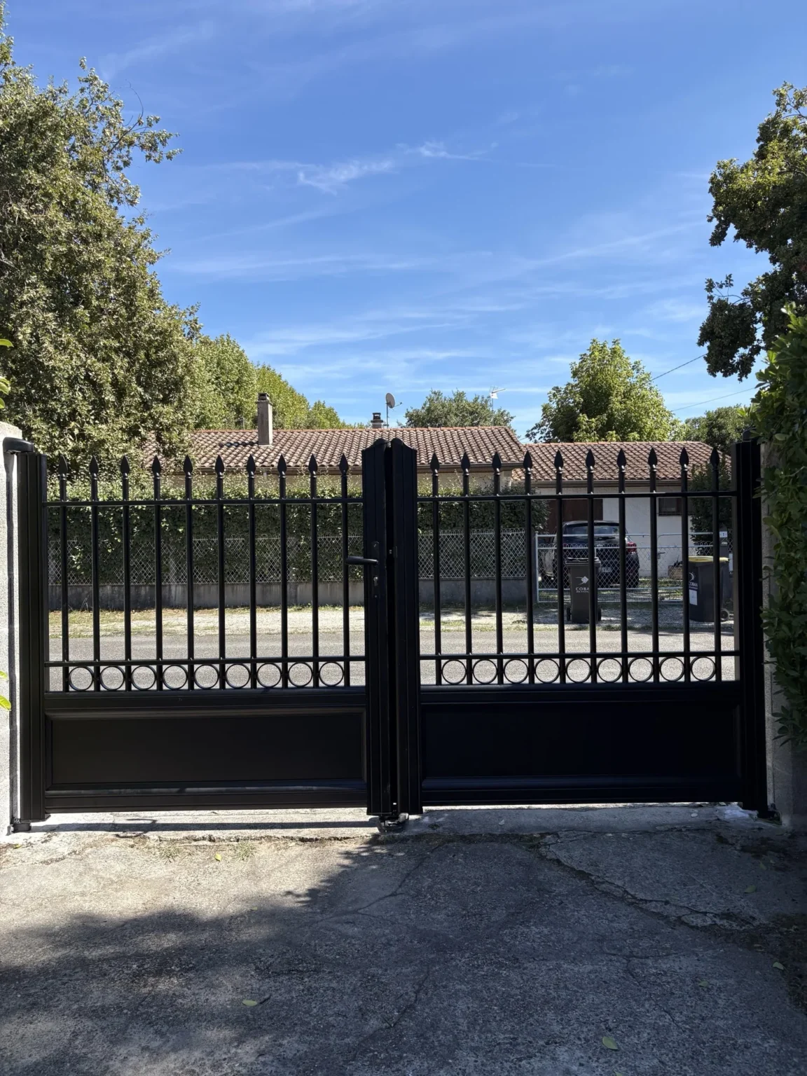 Le portail vu depuis la propriété, côté jardin, avec la rue en arrière-plan