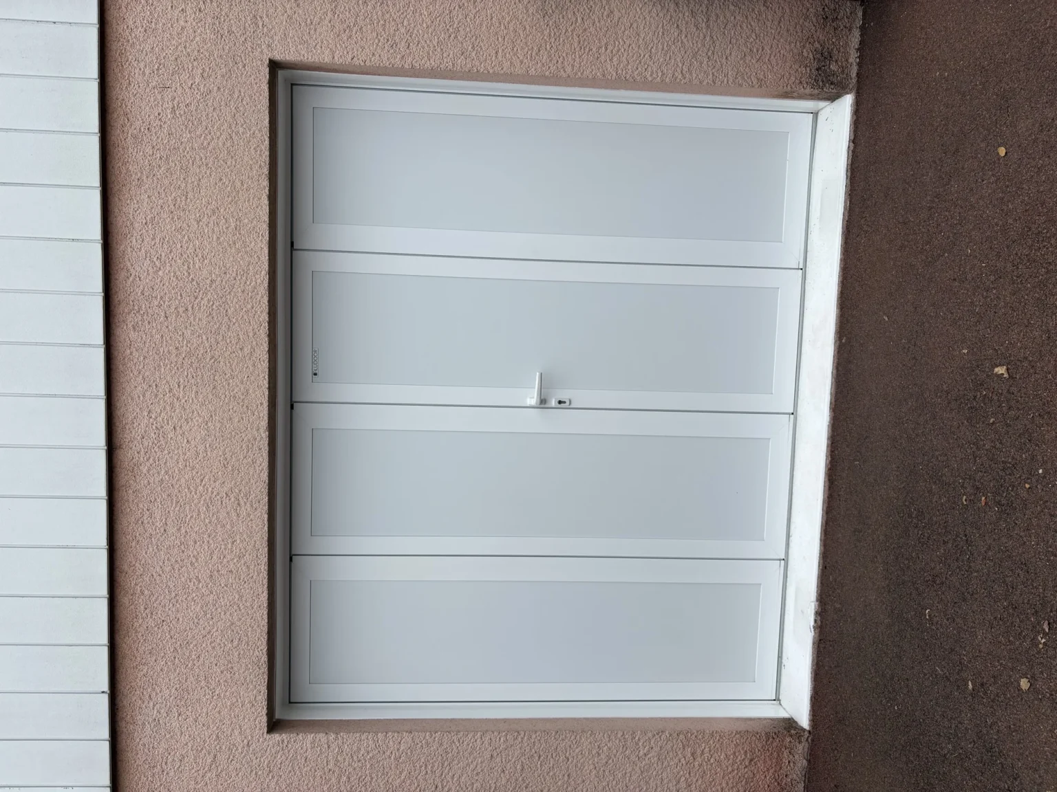 Porte de garage battante Aludoor à quatre vantaux blancs, vue de face sous le bardage de la maison